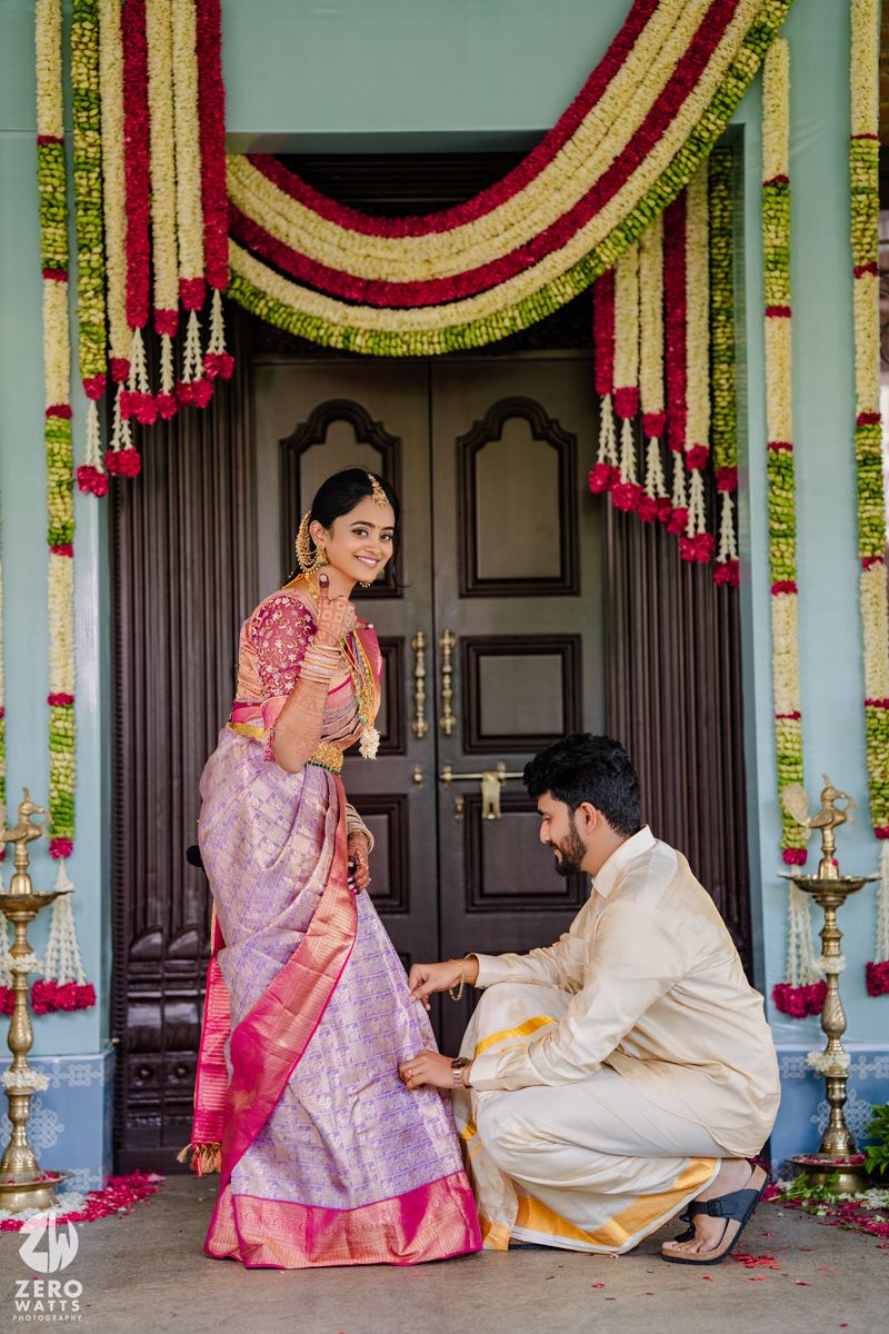Traditional ceremony under flower garland decorations with bride in pink silk saree.