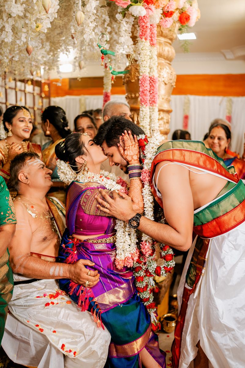 Traditional South Indian wedding ceremony moment with colorful attire and floral decorations during an intimate celebration.