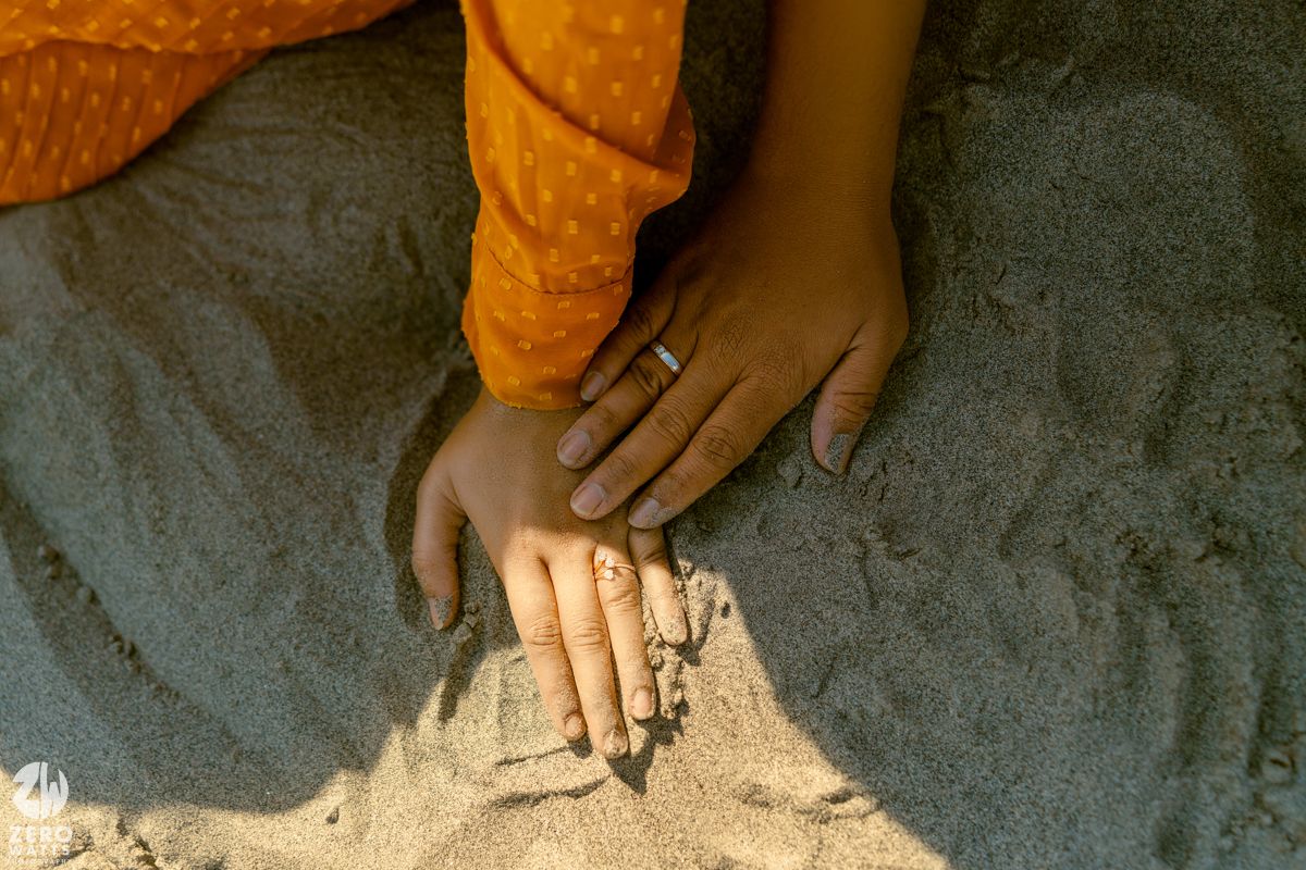 Hands playing with sand during a desert photoshoot.
