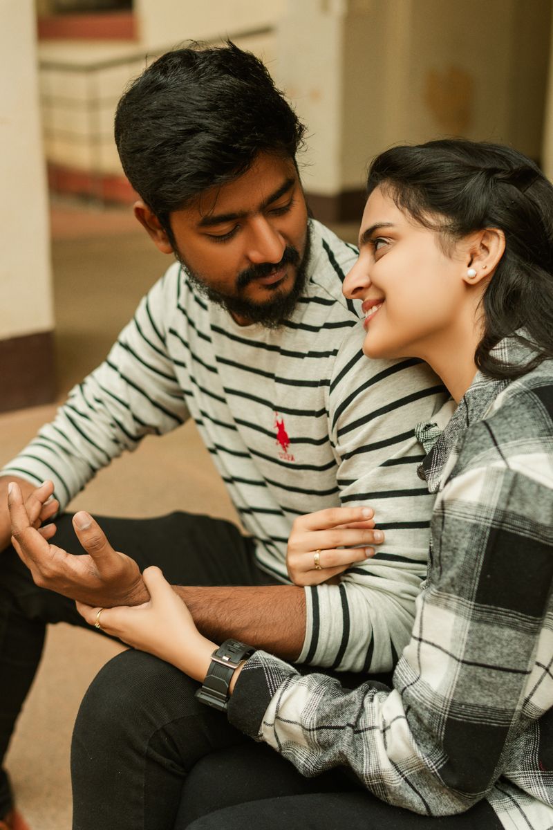 A couple in matching striped sweaters share an intimate conversation indoors.