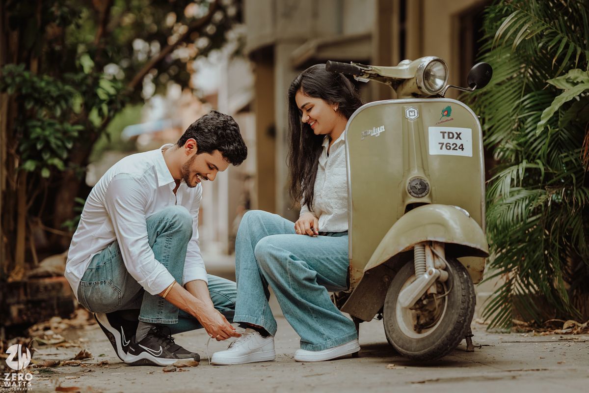 A candid moment captured near a vintage Vespa scooter on a quiet street.