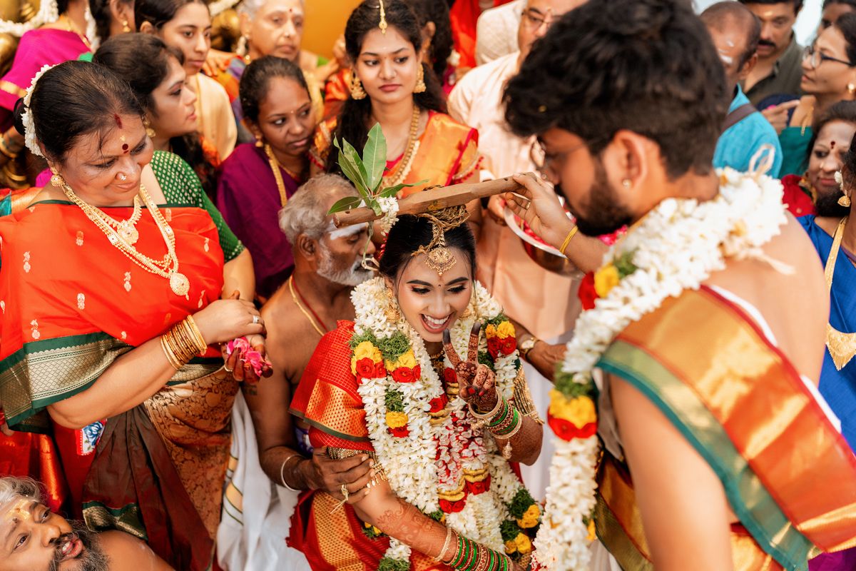 Traditional South Indian wedding ritual being performed with family members gathered around in colorful attire.