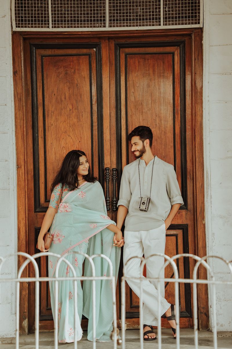 Vintage-inspired photography session against wooden doors and white colonial architecture.