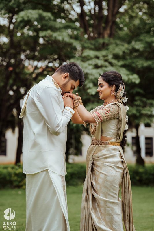 A couple in traditional South Indian attire share an intimate moment outdoors during a wedding photoshoot.