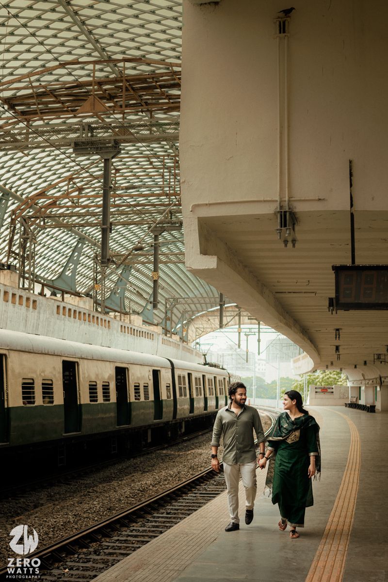 A couple walks together along a historic train platform with beautiful architectural details.