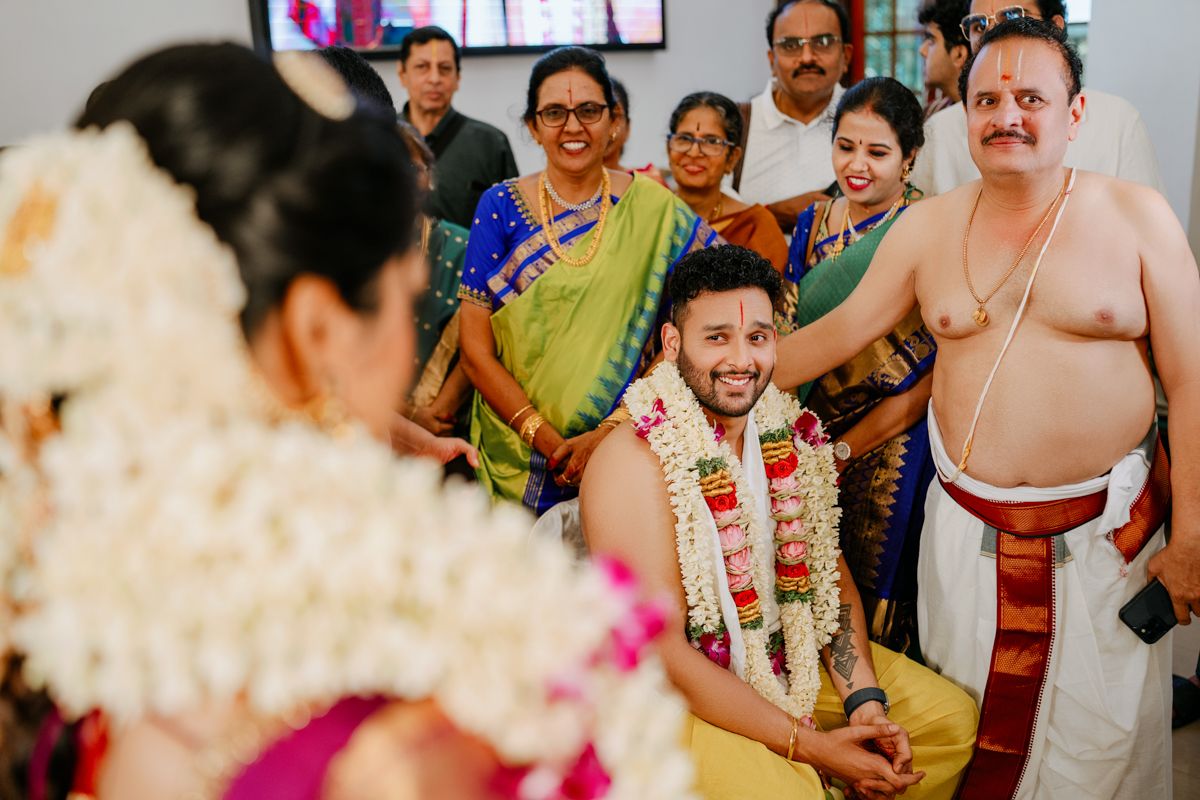 Family members gather for traditional South Indian wedding rituals in festive traditional attire.