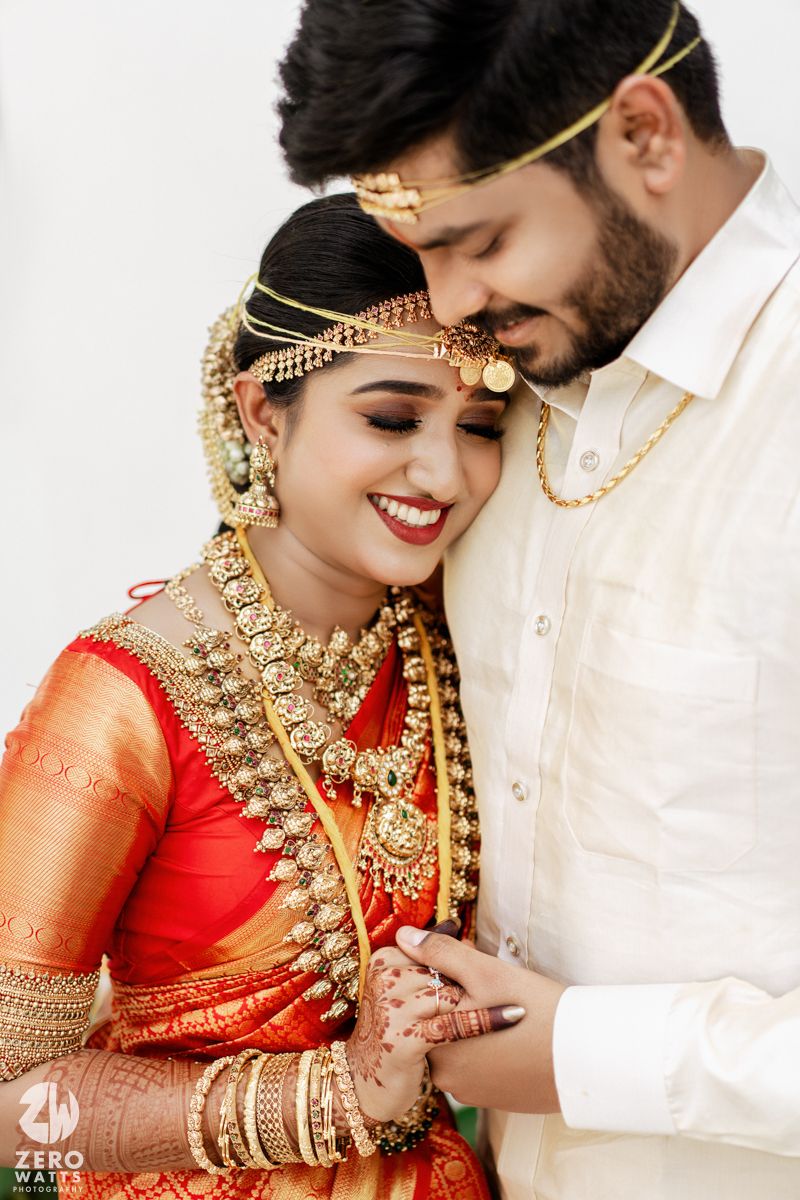 A romantic wedding portrait showcasing ornate South Indian bridal jewelry and traditional attire.