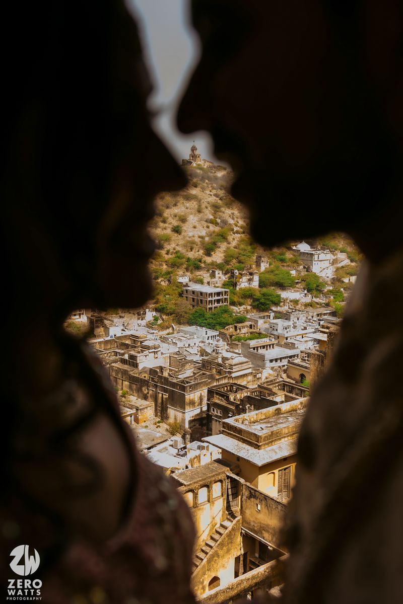 Aerial view of Indian city buildings and architecture framed through silhouetted window perspective.