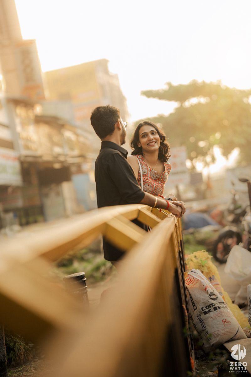 Happy couple enjoying sunset view from urban balcony with warm lighting.