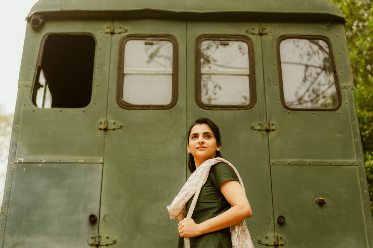 A vintage-style portrait against an army green vehicle showing traditional dress.