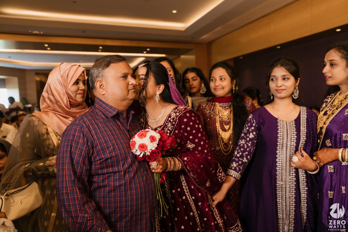 Group of people in traditional Indian attire gathered at a formal indoor celebration.