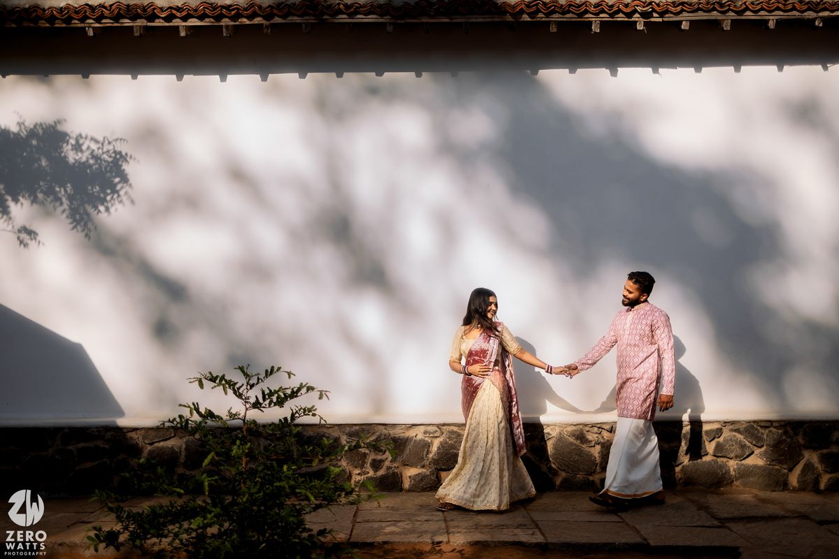 Romantic scene against a white wall with dramatic shadow patterns.