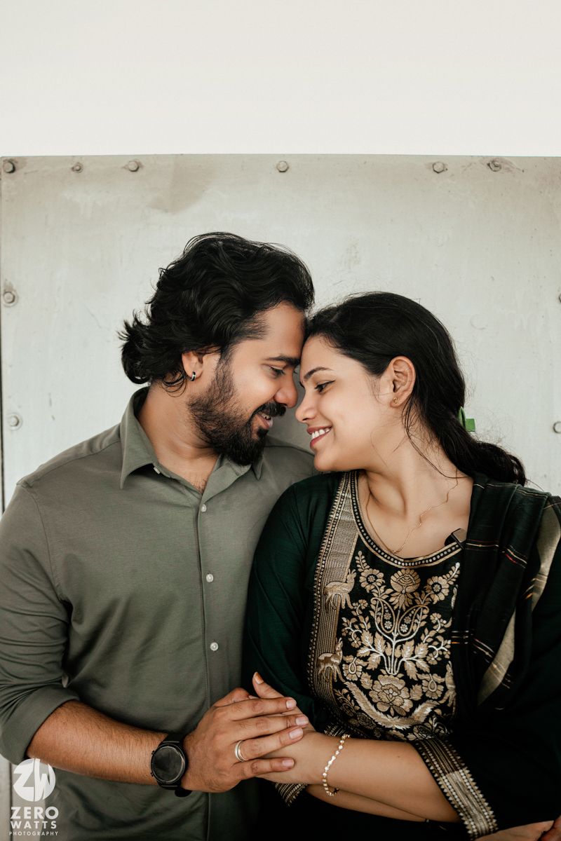 A couple shares an intimate close-up moment while dressed in casual and traditional attire.