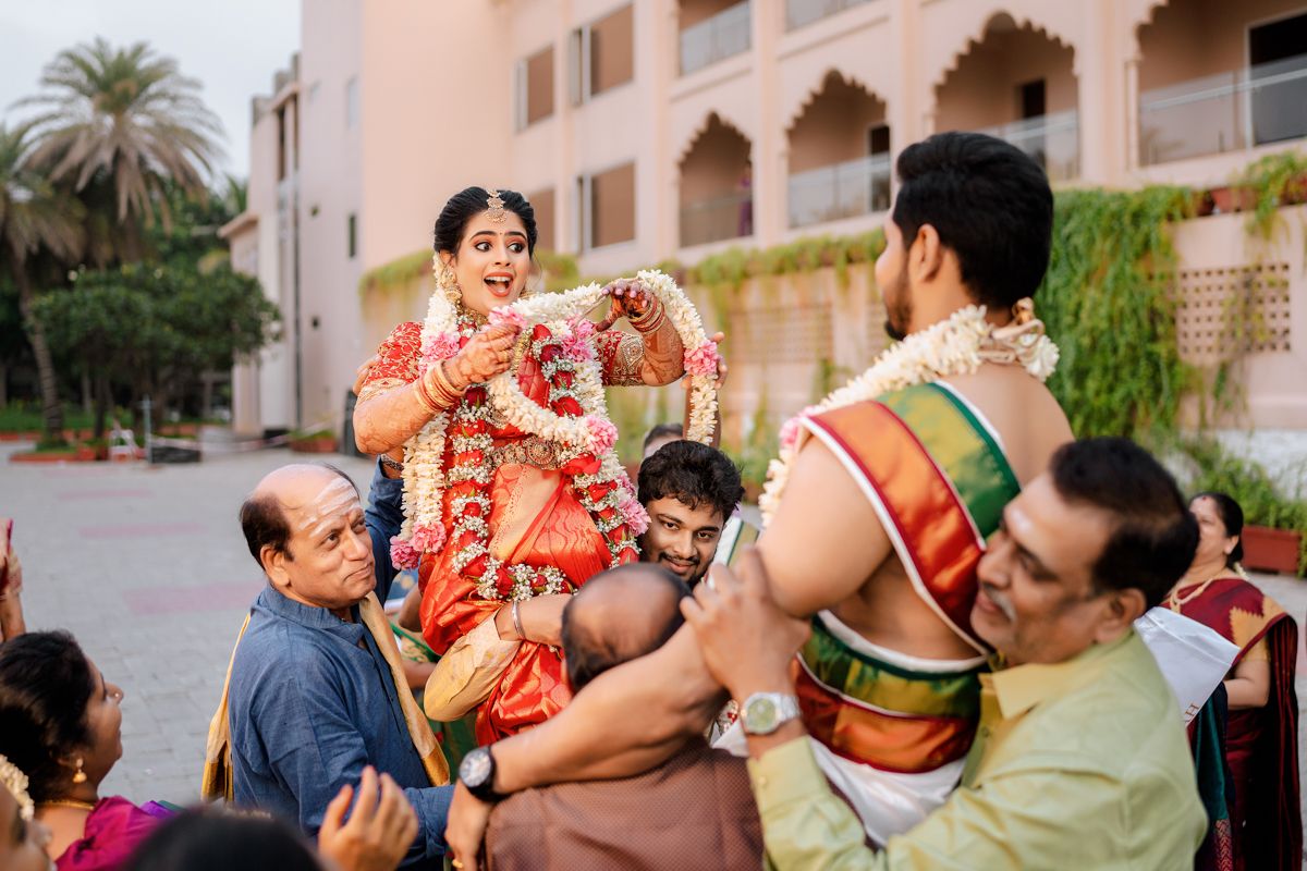 Several people celebrate a traditional Indian wedding ritual with music and dancing outdoors.