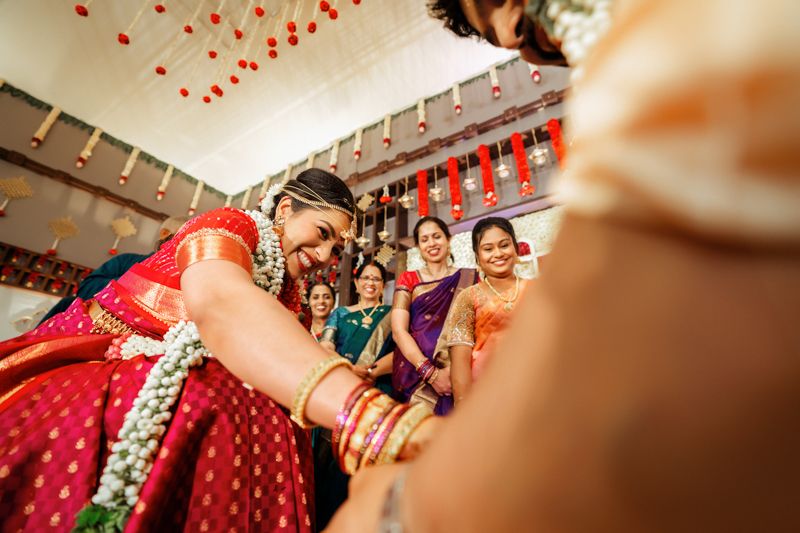 Celebratory moments captured during a traditional Indian wedding ceremony with vibrant red decor and joyful expressions.