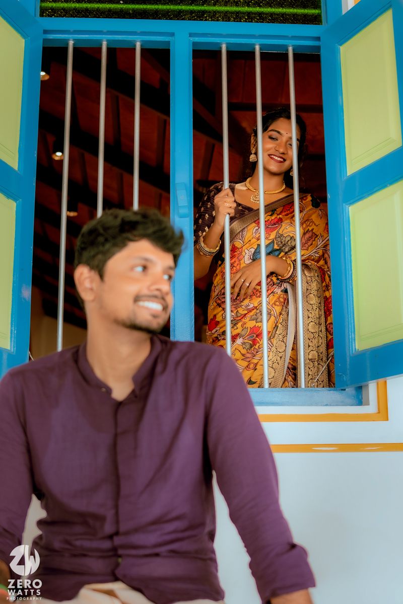 Colorful framed window scene with traditional Indian clothing and decor.