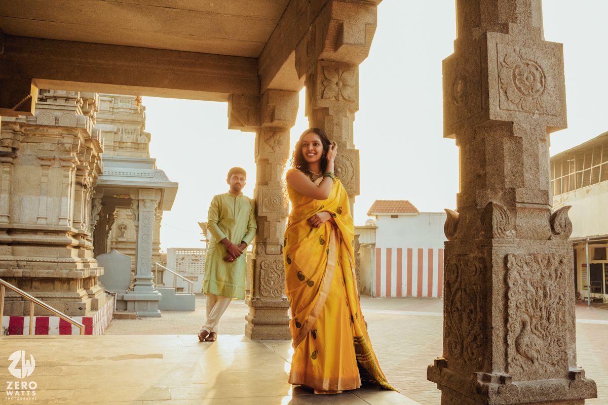 Traditional South Indian architecture with ornate pillars and temple details in warm sunlight.