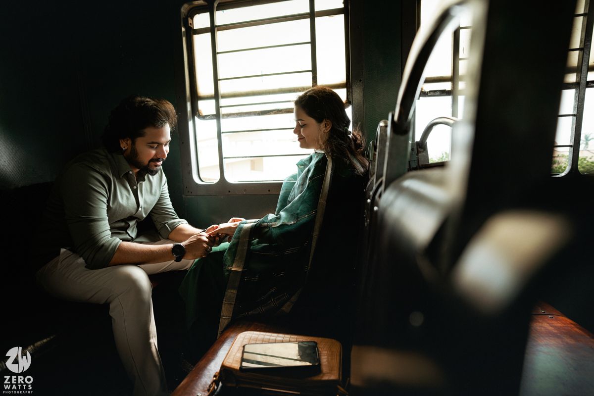 Intimate conversation between two passengers on a moving train with sunlight streaming through windows.