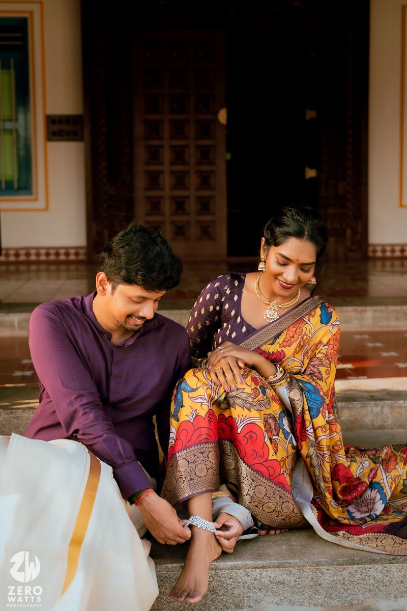 Traditional couple sharing a joyful moment while seated on steps outside their home.