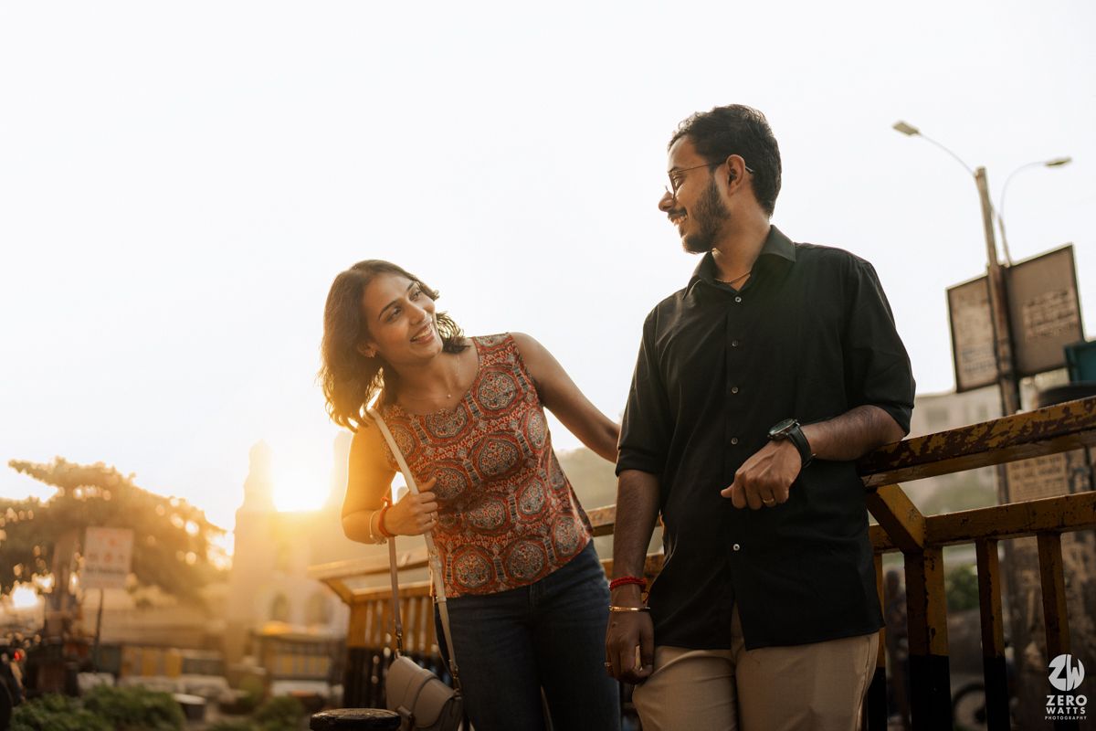 Joyful couple sharing a tender moment during golden hour photoshoot.