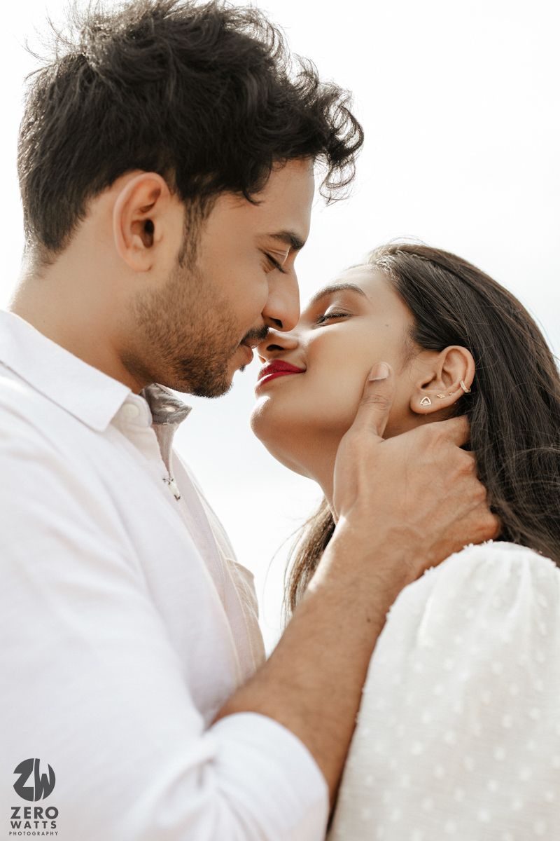 An intimate close-up portrait of a couple sharing a romantic moment together in white outfits.