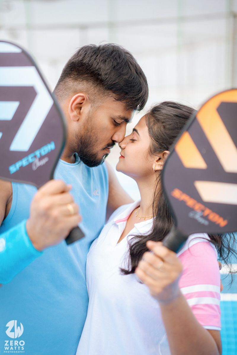 A tender moment between a couple in athletic wear against sports equipment background.