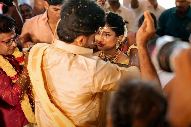 Guests enjoying a traditional Indian wedding celebration with festive attire and joyful dancing in warm lighting.