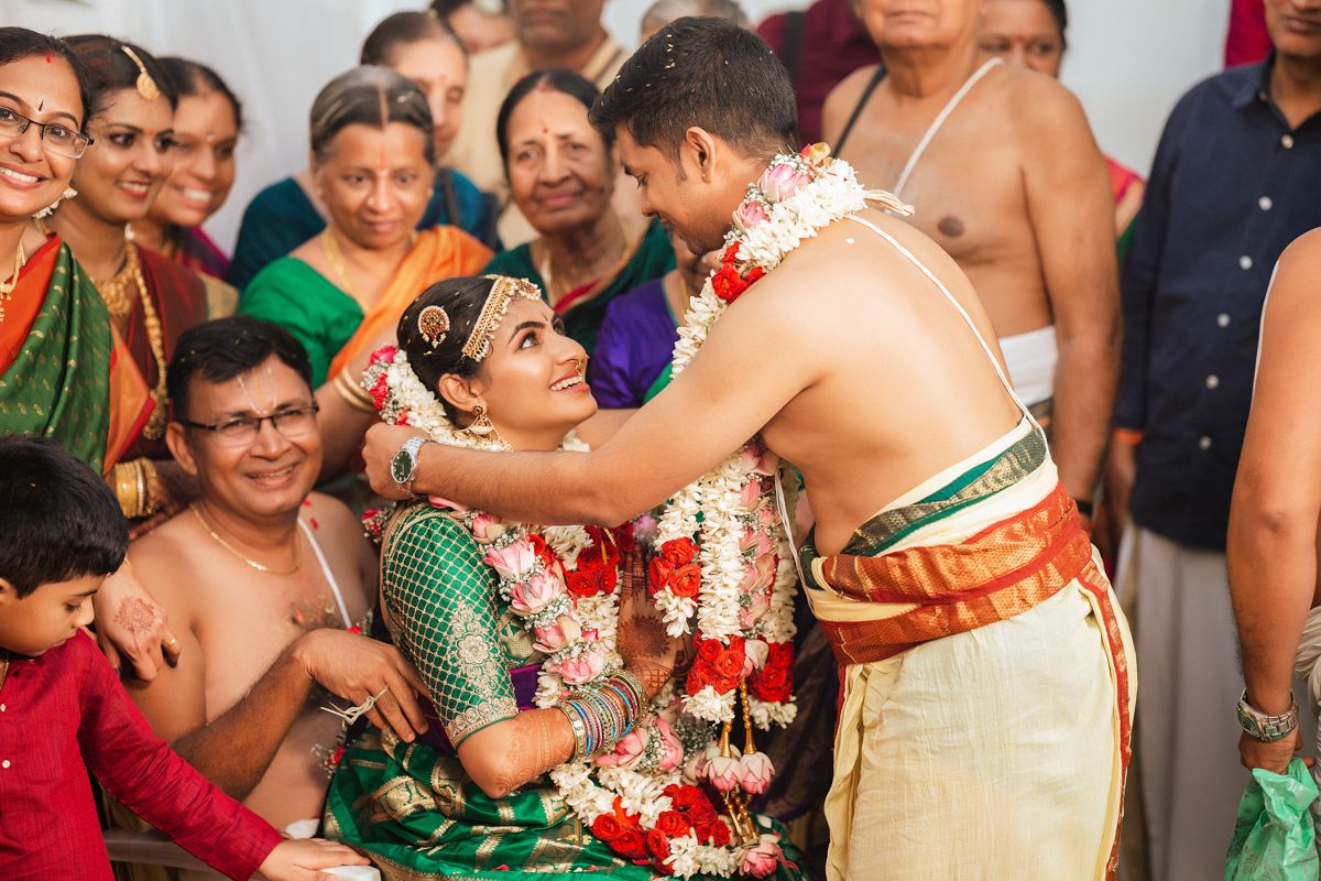 Traditional South Indian wedding ceremony with colorful attire and rituals surrounded by family and guests.