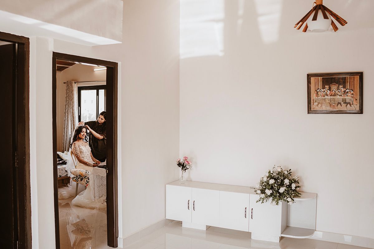 White modern interior with doorway, cabinets, and floral arrangements in a minimalist design setting.
