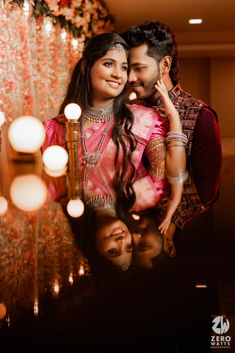An intimate wedding portrait with soft bokeh lighting and floral decorations creating a dreamy atmosphere.