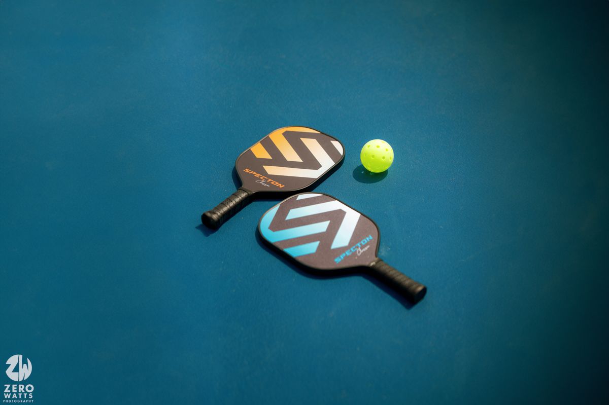 Tennis ball and racket motion blur shot on dark blue background.