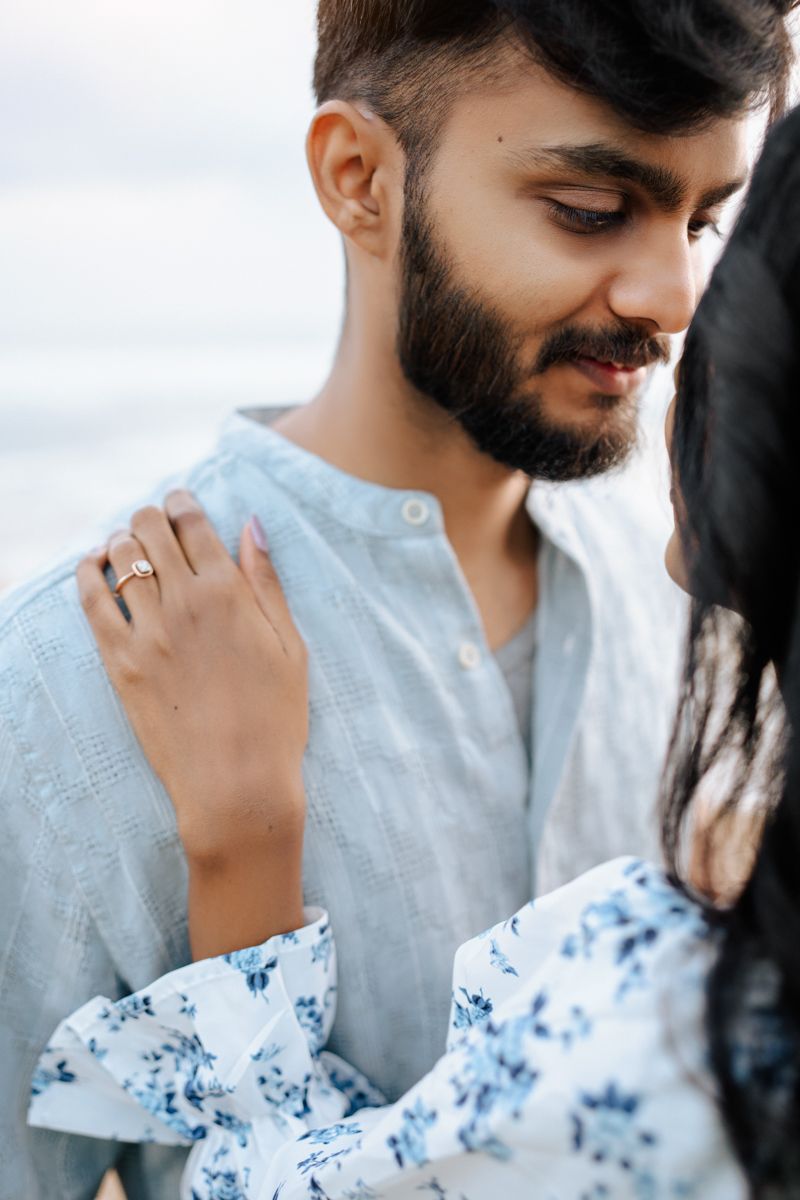 A tender moment captured between two people in white and floral blue outfits.