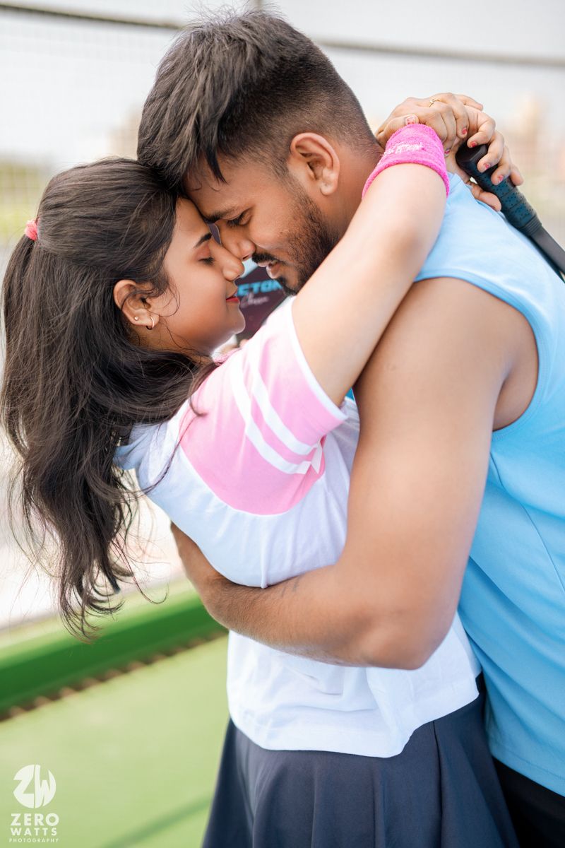 Tender moment shared between couple in athletic wear on an outdoor sports court.