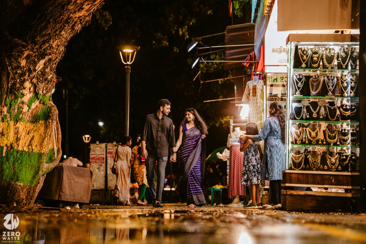 A romantic evening stroll captured on a street lined with festive lights and decorations.