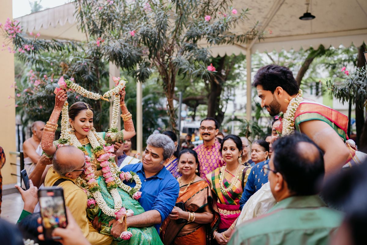 A joyful group celebrates at an outdoor party with traditional festive decor and colorful attire.