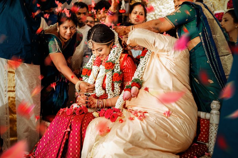 Traditional Indian wedding ceremony with ornate garlands and bright red attire during an intimate cultural moment.