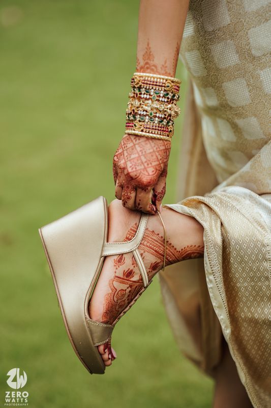 Close-up of decorated feet with traditional jewelry and henna.