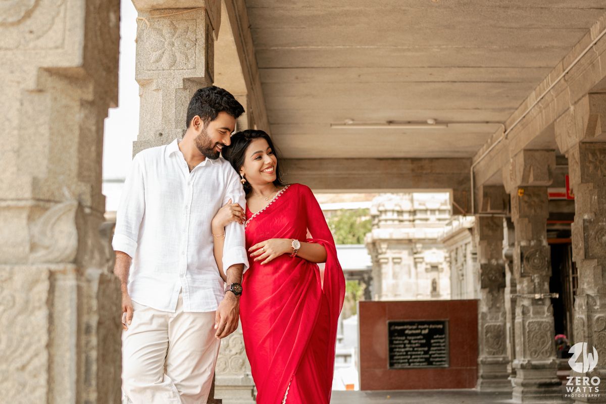 A romantic moment captured in a temple hallway with carved stone columns and traditional Indian attire.