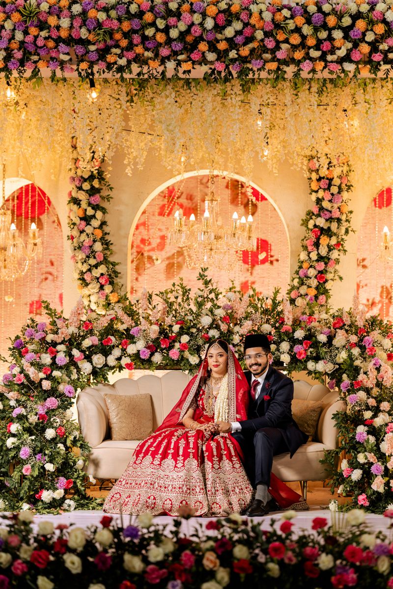 Wedding ceremony setup with lavish floral decor and arched backdrop for a South Asian celebration.