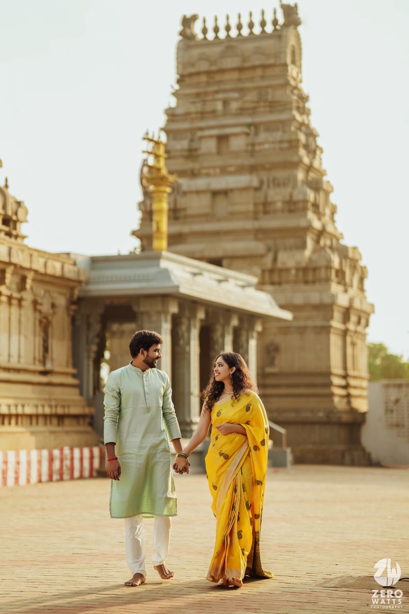 Traditional Indian temple visit with couple in formal ethnic attire walking hand in hand.