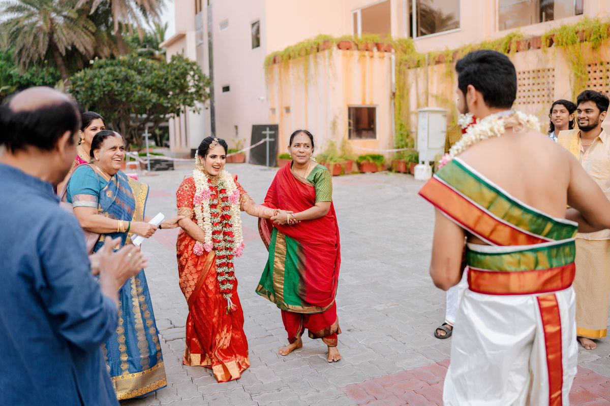 Guests in colorful traditional Indian attire gather outside during a wedding celebration.