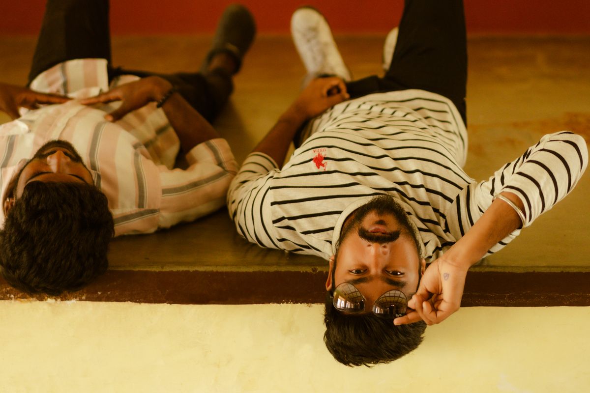 Two people lying on a floor, one wearing a striped shirt, captured from above.