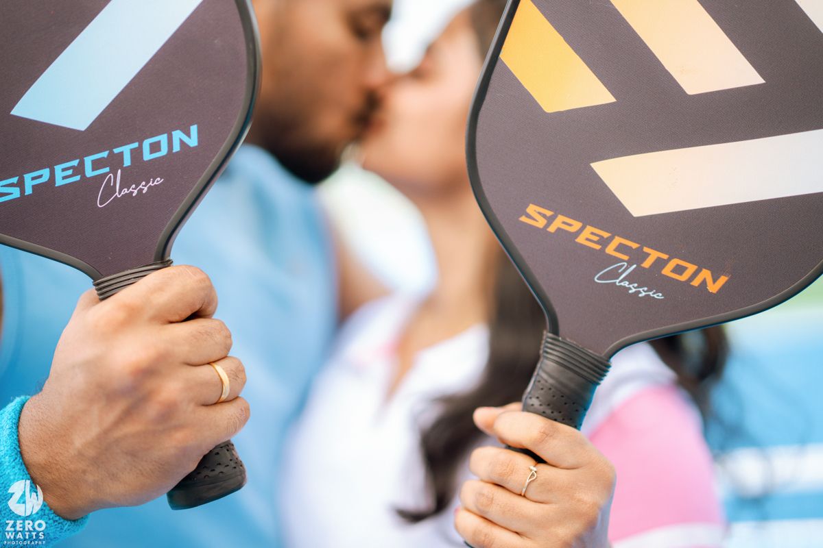 Close-up of pickleball paddles being held together during a romantic moment on the court.
