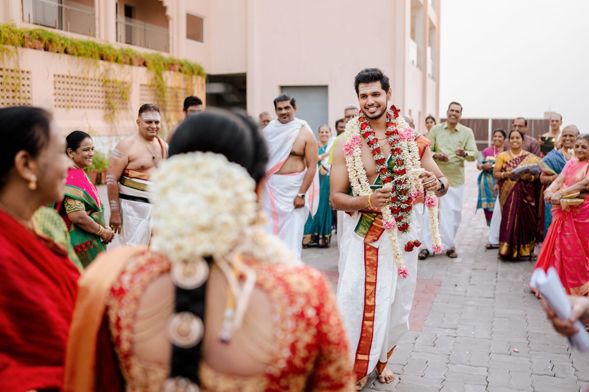 A joyful Indian wedding celebration with traditional attire and decorations taking place outdoors on a terrace.