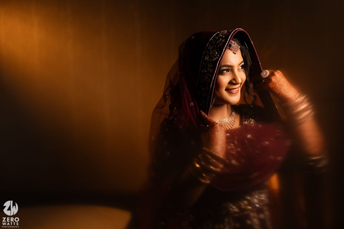 Portrait of figure in traditional attire captured against warm amber lighting with glittering effect and bokeh details.