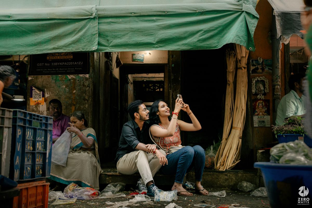 Couple sharing drinks together at street market stall with green awning.