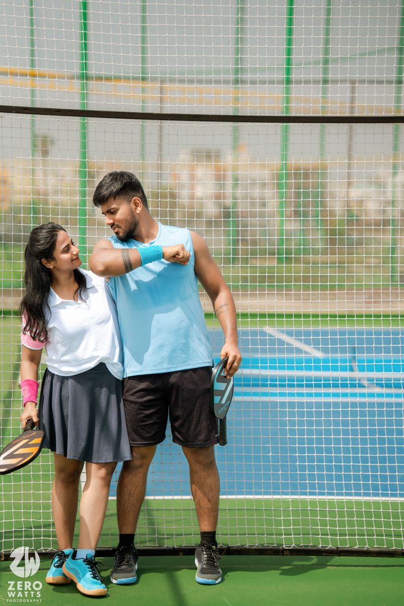 Athletic pair sharing a playful moment on an outdoor sports court.