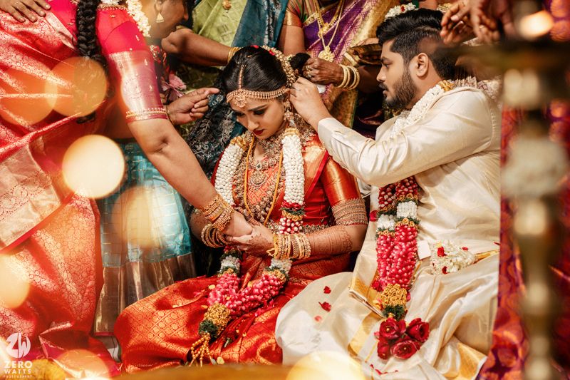 A collage of traditional Indian wedding ceremony moments showing hands, jewelry and rituals in warm red tones.