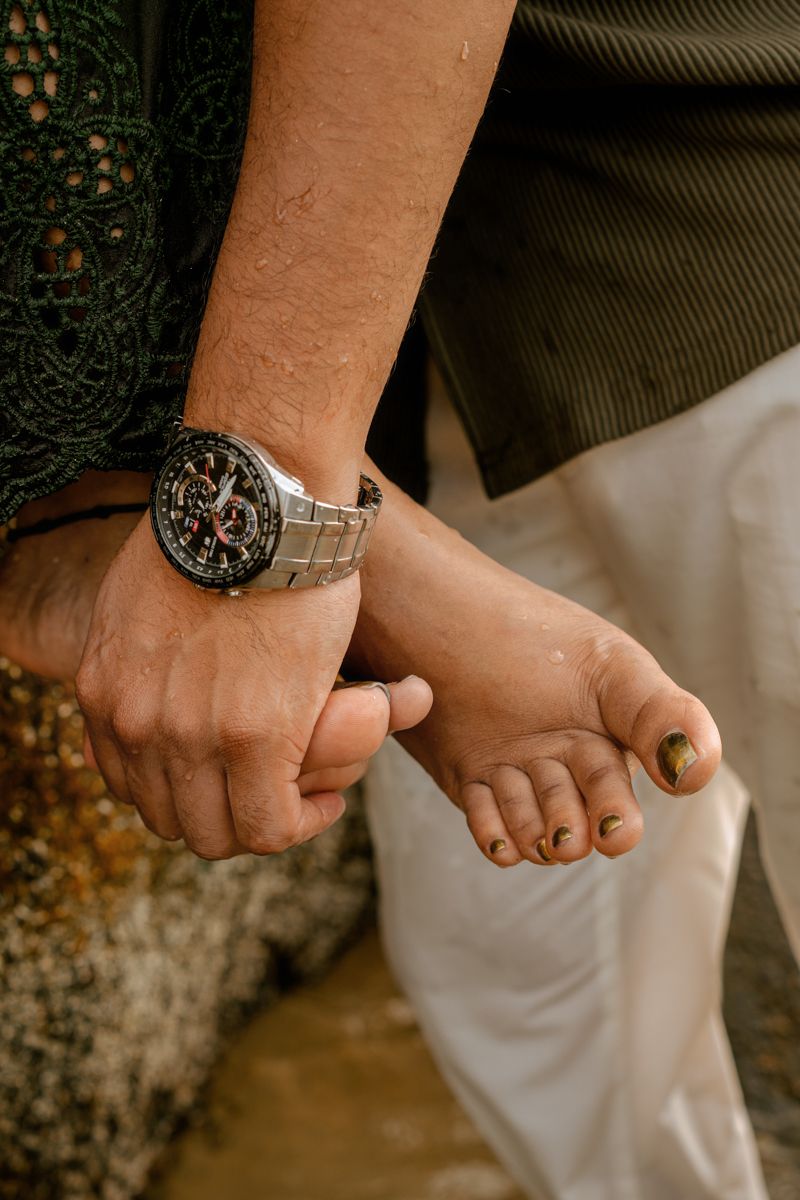 Close-up of a person's wrist wearing a silver watch with ornate details.
