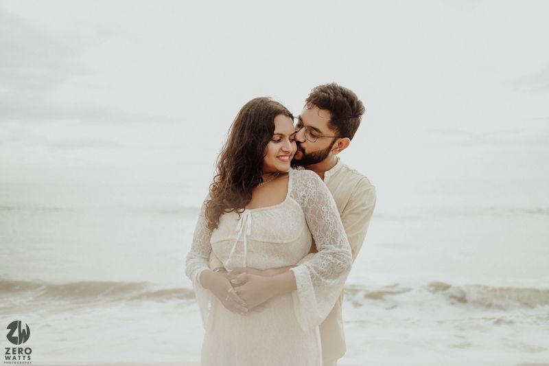 A loving embrace captured against the backdrop of a cloudy ocean.